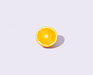 Fresh orange on a pastel purple background. Minimal concept with isolated citrus fruit.