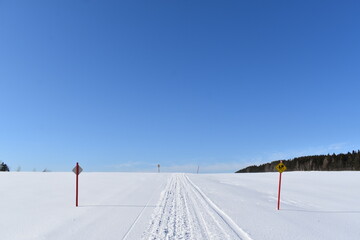 A snowmobile trail under a blue sky, Québec, Canada