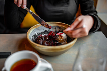 Young woman hand eating chocolate fondant dessert using knife and fork fom bowl