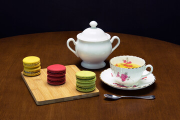 Obraz na płótnie Canvas Tea in Bone China with a colorful assortment of macarons 