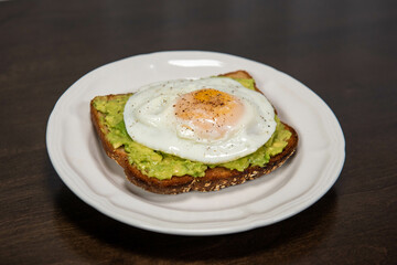 Delicious avocado toast with a fried egg on top.
