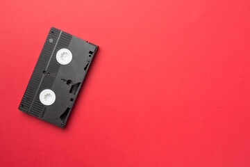 Old analog tape VHS cassette on color background, top view
