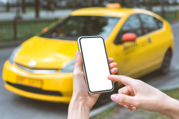Mock-up, a smartphone in the hands of a girl. against the backdrop of a yellow taxi.