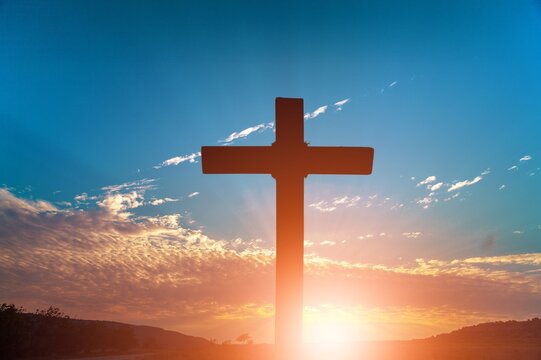 The wooden Cross at the sunset sky background
