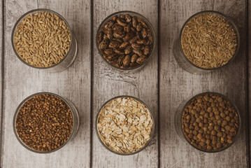 cereals in a glass standing on the table, buckwheat, rice, barley, beans, oatmeal, lentils