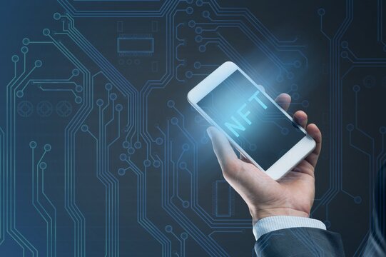 NFT non fungible tokens concept. Businessman with smartphone holding digital hologram