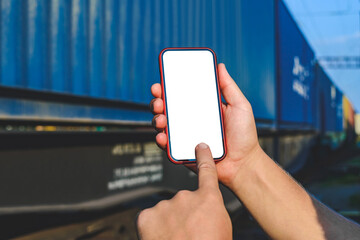 Finger in front of smartphone mockup in male hand. Against the background of a railway car in motion.
