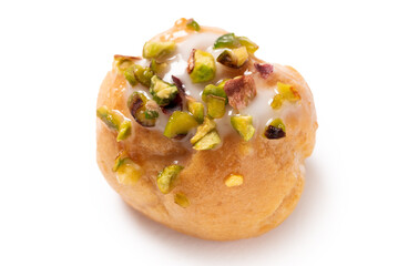 Bignè con glassa e pistacchio isolato su fondo bianco 