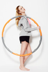 Holding her hula hoop. A gorgeous young woman holding a hula hoop in a studio shoot.