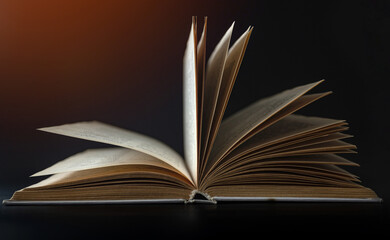 Open book, hardcover books on a dark background.