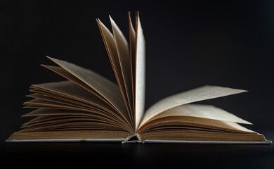 Open book, hardcover books on a dark background.