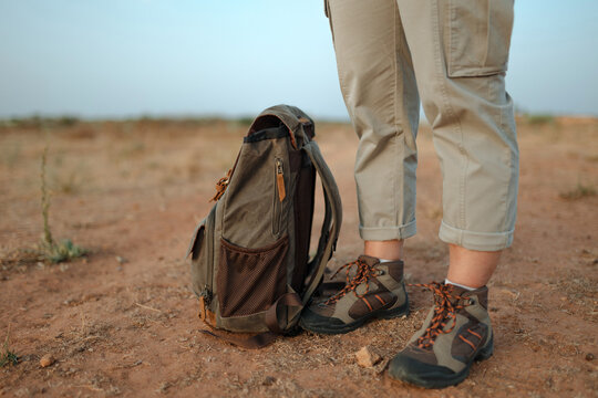 Unrecognizable traveler in desert with backpack