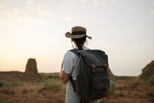 Anonymous traveler standing in desert field