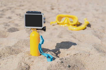 Mockup Waterproof action cameras close up with yellow float in the sand on the beach. Against the...