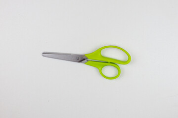 Kid scissors with green handle on white background