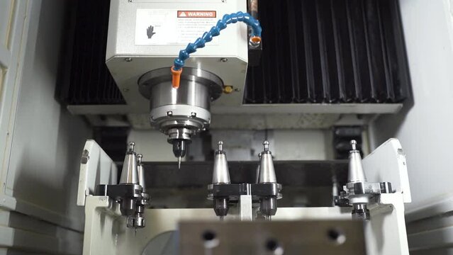 CNC machine selecting and inserting a detachable drill from a set.