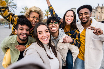 Multiracial group of friends taking selfie picture together with smart mobile phone outside - Happy teens walking on city street enjoying weekend activities - Happy people and youth lifestyle concept - obrazy, fototapety, plakaty