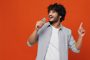 Young bearded Indian man 20s years old wears blue shirt sing song in microphone dance sing song...