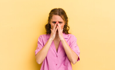 young pretty woman feeling worried, hopeful and religious, praying faithfully with palms pressed,...