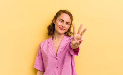 young pretty woman smiling and looking friendly, showing number three or third with hand forward,...