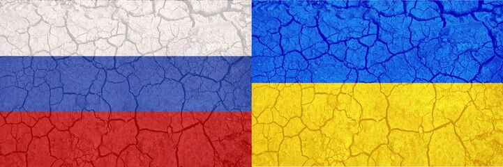 Ukraine and Russia two flags on flagpoles banner on cracked earth background