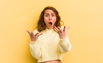 young pretty woman feeling extremely shocked and surprised, anxious and panicking, with a stressed...