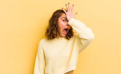 young pretty woman raising palm to forehead thinking oops, after making a stupid mistake or...