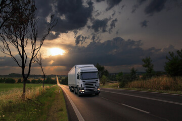 Landscape with a moving truck at sunset 