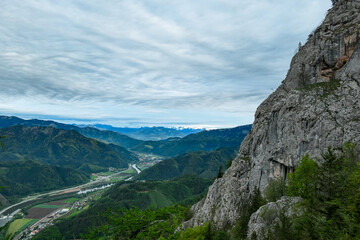 A rock formation with scenic view from mount Roethelstein near Mixnitz in Styria, Austria. Landscape of green alpine meadow and a small village in the valley of Grazer Bergland in Styria, Austria