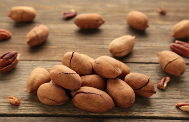 Pecan nuts on a brown wooden table.