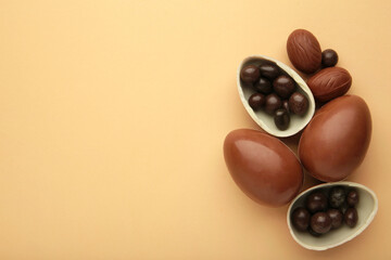 Chocolate Easter eggs and sweets on beige background with copy space