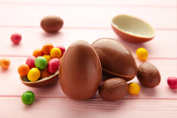 Chocolate easter eggs on wooden pink background.