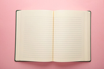 Blank open notepad on a pink background.