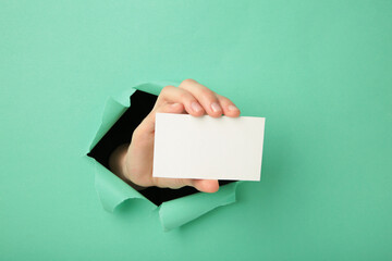 Female hand with gift box punching through the pink paper