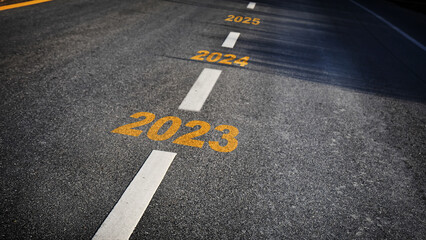 Number of 2023 to 2025 on asphalt road surface with marking lines, happy new year concept and...