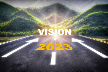 Road to 2023 vision on asphalt road surface with arrow sign on the mountain background. Beginning...