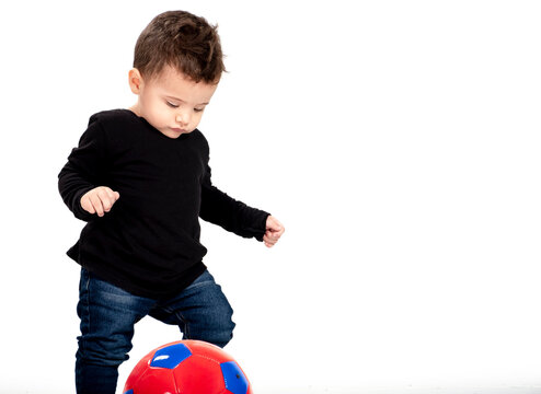  beautiful baby boy kicks soccer ball, isolated white background, copy space