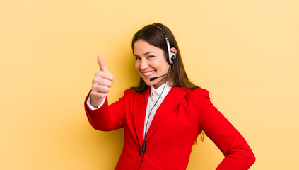 young pretty woman feeling proud,smiling positively with thumbs up. telemarketer concept