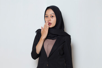 Young asian muslim business woman shocked covering mouth with hands for mistake. Secret concept.
