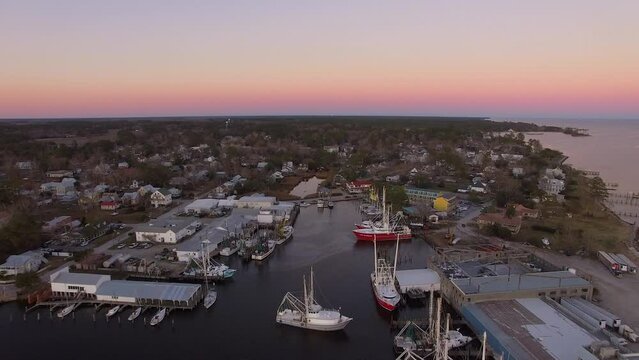 Aerial Drone Flyover of Oriental NC Harbor and town docks at sunset forward flight with Diesel Spill facing north