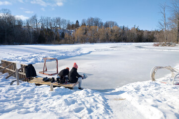 Toronto, Ontario / Canada, 02/12/2022: Resting on the park bench after Ice-skating in the natural ice rink.