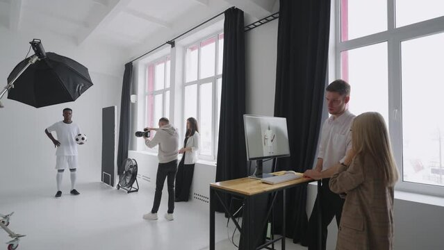 backstage of professional photosession of afro-american footballer in studio for magazine