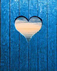 Herz in einer Holzwand mit Blick zum Meer