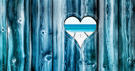 Herz in einer Holzwand mit Blick zum Meer