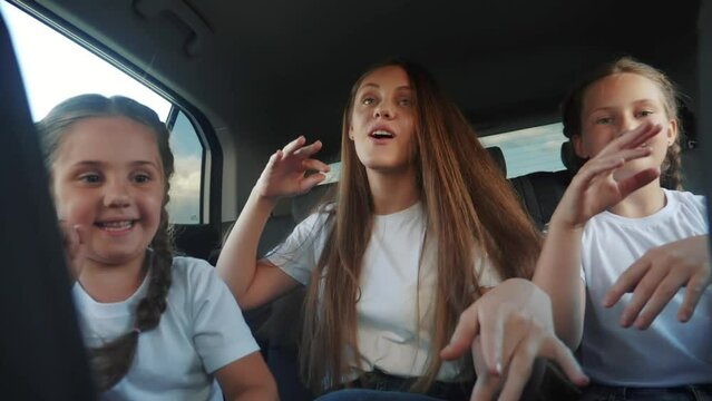 children teenagers dancing in the car on the road travel. happy family adventure a kid dream concept. friendly family sisters dancing fun having to the music in the car on the way to vacation
