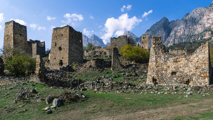 Fototapeta na wymiar An abandoned medieval town. A complex of towers in the mountains of Ingushetia. Military and residential ancient towers built of stones. Landscape in the mountains with a view of the ruins.