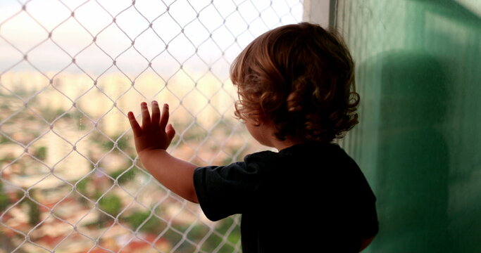 Baby Child Hand Leaning On Window Balcony With Safety Net