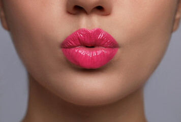 Closeup view of beautiful woman puckering lips for kiss.on grey background - obrazy, fototapety, plakaty