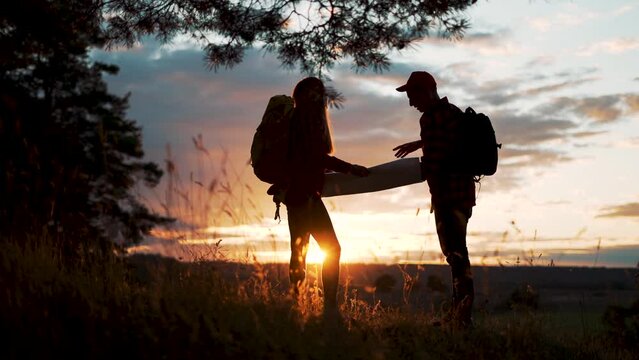 Family tourism with map in forest. Team orienteering in forest. Family travel with map. Teamwork concept. Team of tourists in a forest park with a map. Tourists hiking. Family travel in forest park