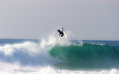 Surfer athletes riding the crazy blue waves of Portugal